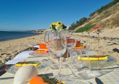 Déjeuner sur la plage avec parapentes en haut de la dune